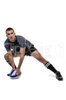 Sports player in black jersey stretching with ball