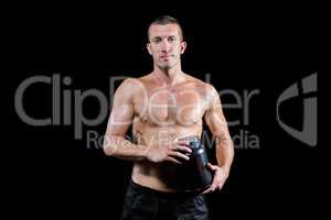 Confident shirtless man holding nutritional supplement