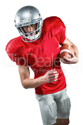 American football player in red jersey looking down while holdin