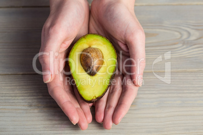 Woman showing fresh avocado