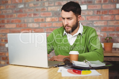 Serious businessman working on laptop