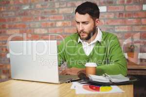 Serious businessman working on laptop