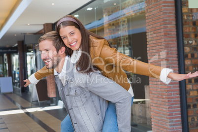 Young man giving a young woman a piggy ride