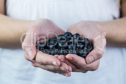 Woman showing handful of blueberries