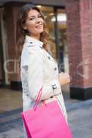 Portrait of smiling woman with shopping bag looking at camera