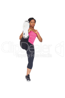 Fit woman kicking to camera