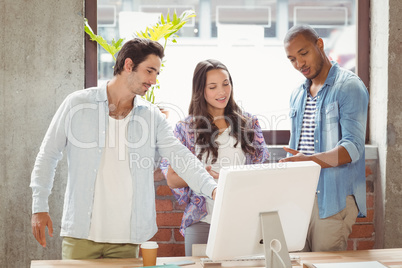 Business people pointing towards laptop in office