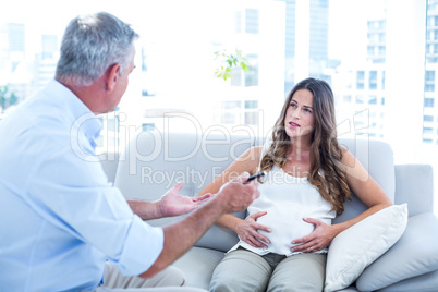 Therapist advising preganant woman at home