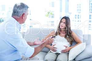 Therapist advising preganant woman at home