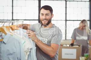 Portrait of happy man choosing clothes for donation