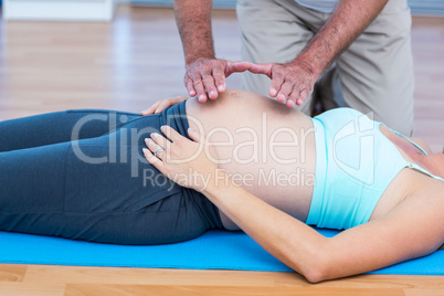 Relaxed pregnant woman getting reiki treatment