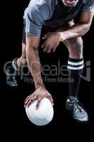 Low section of rugby player holding ball