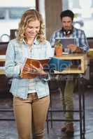 Happy businesswoman looking at file in office