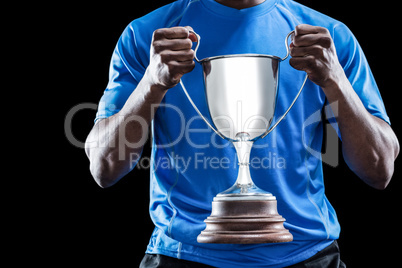 Mid section of sportsman holding trophy