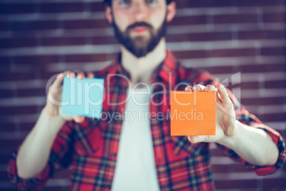 Portrait of man holding orange and blue adhesive notes