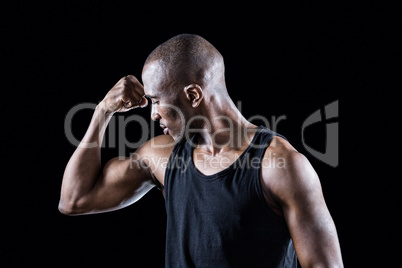 Athlete looking at bicep while flexing muscles