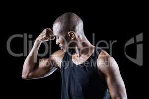 Athlete looking at bicep while flexing muscles
