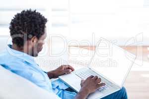 Young man working on laptop at home