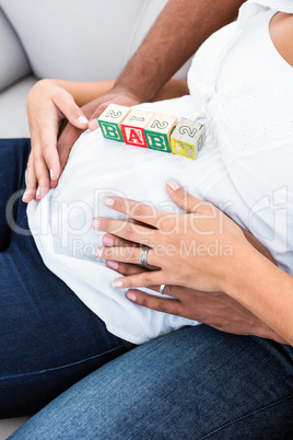 Midsection of pregnant woman belly with toy