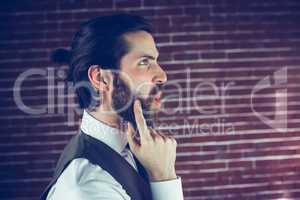 Side view of hipster with hand on chin thinking