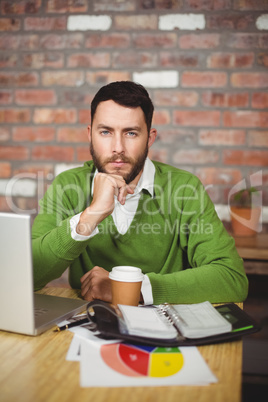 Portrait of serious businessman with hand on chin