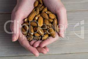 Woman showing handful of almonds