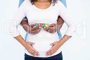 Midsection of husband with wife holding baby text