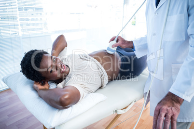 Smiling pregnant woman looking towards monitor