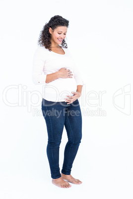 Happy pregnant woman holding abdomen