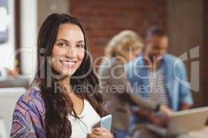 Portrait of smiling woman holding digital tablet in office