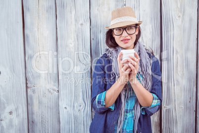 Happy hipster holding a cup in her hand