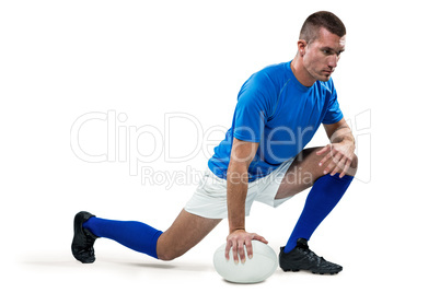 Rugby player stretching with ball