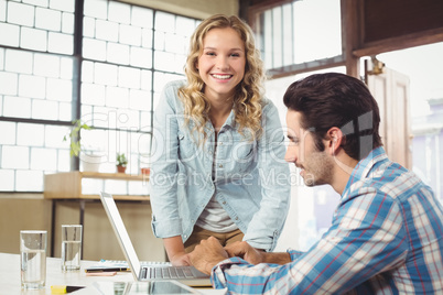 Portrait of woman helping colleague