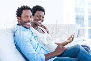 Portrait of happy couple with digital tablet