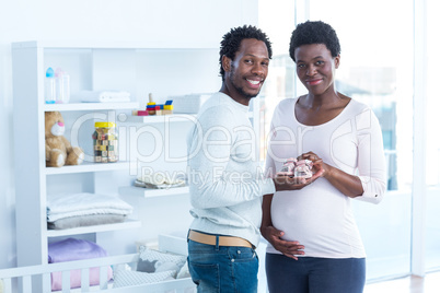 Smiling woman giving baby shoes to her husband