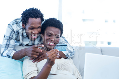 Happy pregnant woman with husband pointing at photo