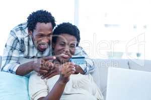 Happy pregnant woman with husband pointing at photo