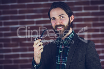 Portrait of smiling handsome man smoking pipe