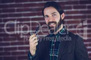Portrait of smiling handsome man smoking pipe