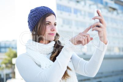 Cold brunette in warm clothes taking photos