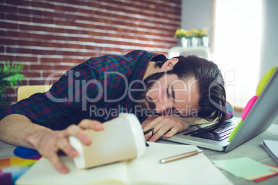 Tired editor holding disposable cup