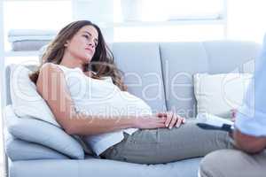 Sad pregnant woman relaxing at home