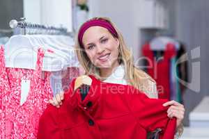 Smiling woman holding red coat
