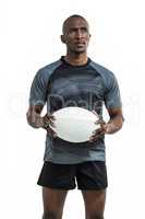 Thoughtful sportsman holding rugby ball