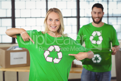 Portrait of woman pointing towards recycling symbol on tshirts