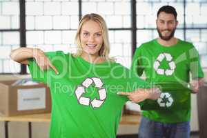 Portrait of woman pointing towards recycling symbol on tshirts