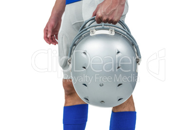 Midsection of American football player handing his helmet