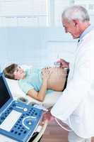 Doctor doing ultrasound on belly of pregnant woman