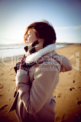 Slim woman looking at the sea during the sunset