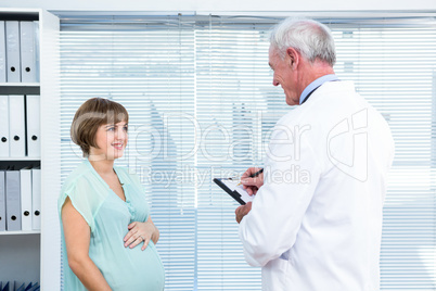 Happy pregnant woman talking with doctor Happy pregnant woman talking with doctor